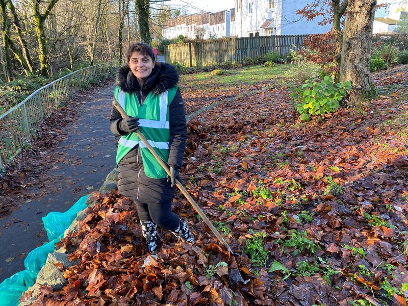 Pam clearing leaves with Milngavie in Bloom volunteers